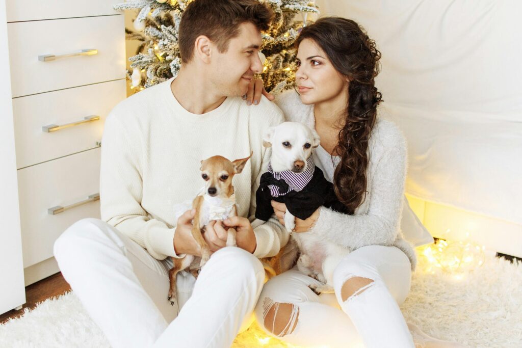 Couple with their dogs enjoying a cozy Christmas indoors, showcasing love and togetherness.